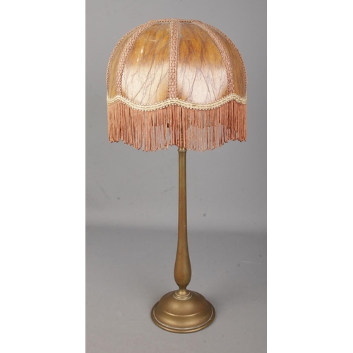 3 - A brass rise and fall table lamp in the style of Benson with fringed shade.