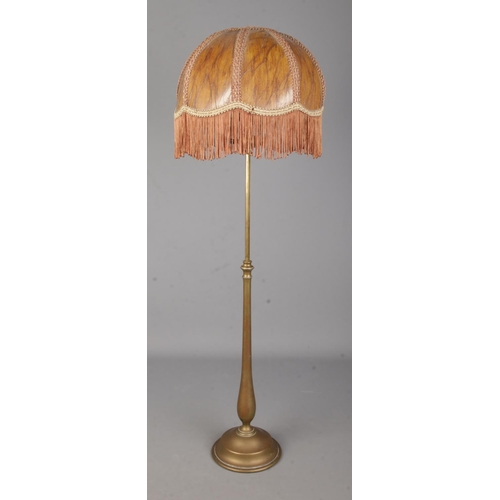 3 - A brass rise and fall table lamp in the style of Benson with fringed shade.