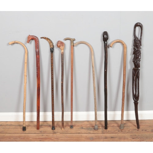 296 - A collection of walking sticks, to include carved, figural and 'Aruba' examples.