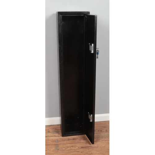 315 - A black painted steel gun safe cabinet with double lock and wall fixing holes to reverse. Includes t... 