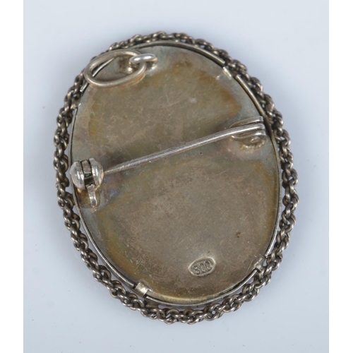 405 - A silver brooch featuring hand painted portrait of a maiden. Stamped 800 to reverse.