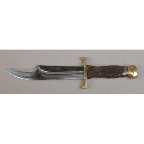 77 - A 'Crocodile Hunter' bowie knife in sheath, with sharpening stone. Blade length 8.25 inches. CANNOT ... 