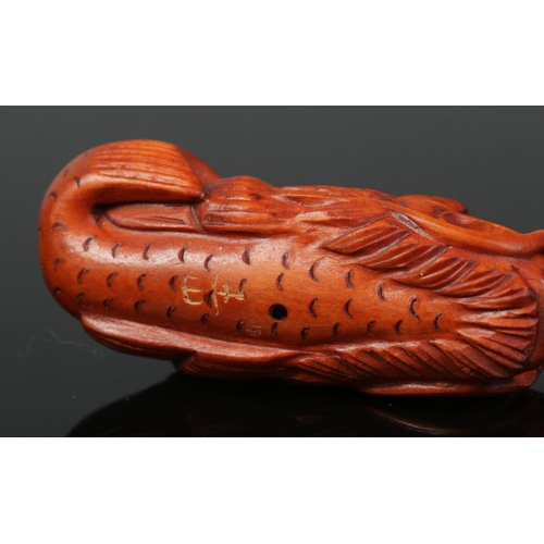 427 - A hand carved hardwood netsuke of a dragon fish. Signed.