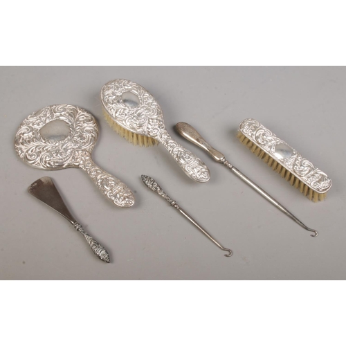 435 - A three piece silver filled dressing table set; having scrolled and masked decoration, together with... 