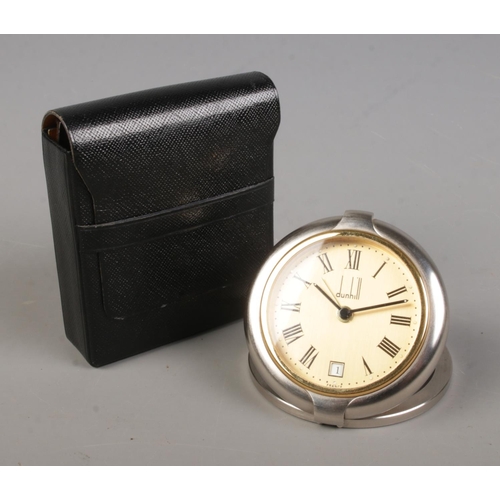 443 - A Dunhill quartz travel alarm clock in case. With Roman numeral markers and date display.