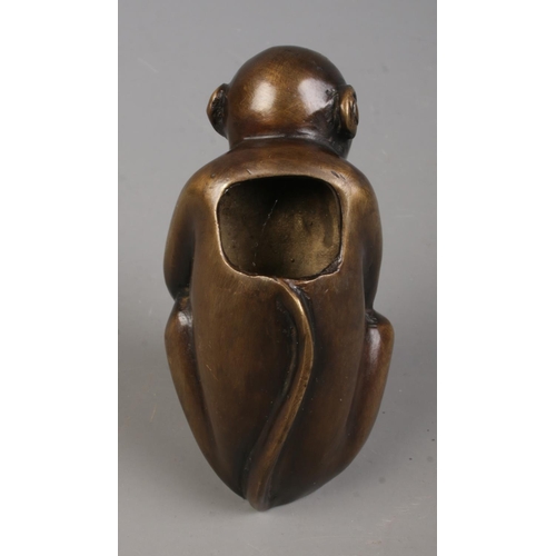 446 - A bronze figure formed as a seated monkey. Approx. height 8cm.