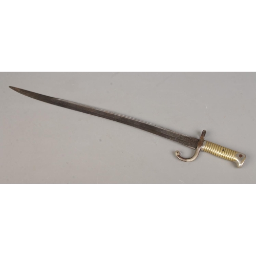 448 - An 1866 pattern French Chassepot sword bayonet, together with a Tommie/Brodie helmet with chin strap... 