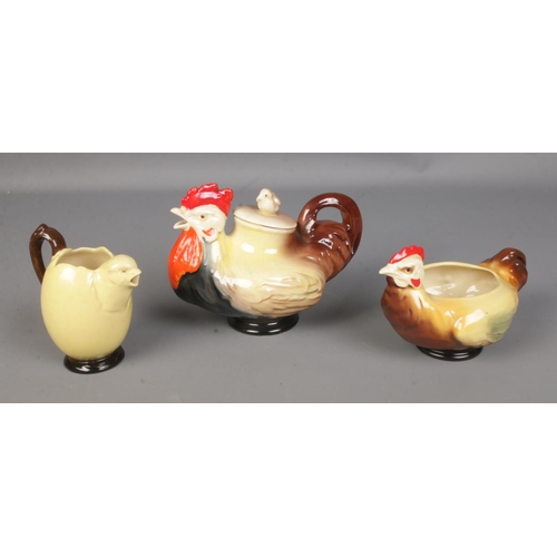 87 - A Royal Doulton chicken family tea service featuring rooster pot, chicken sugar bowl and chick/egg m... 