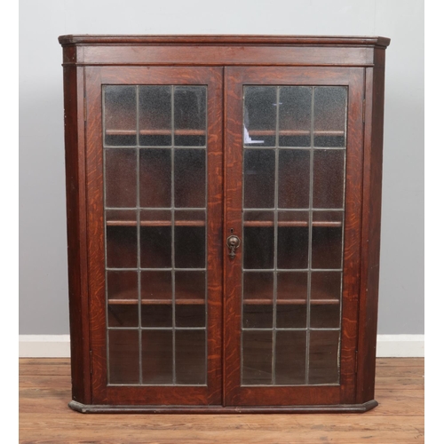 476 - A large Georgian style oak wall mounted corner cupboard, with twin lead glazed doors. Height: 127cm,... 