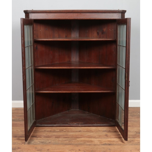 476 - A large Georgian style oak wall mounted corner cupboard, with twin lead glazed doors. Height: 127cm,... 