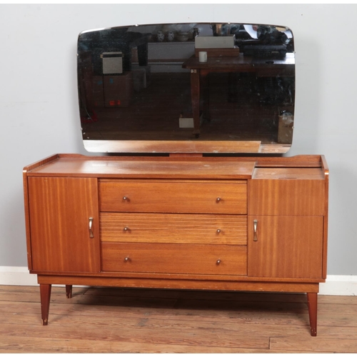 477 - A mid-century Austinsuite teak dressing table, with three drawers flanked by two cupboard doors and ... 