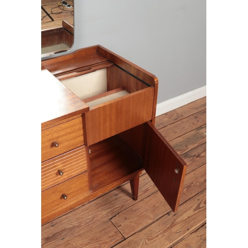 477 - A mid-century Austinsuite teak dressing table, with three drawers flanked by two cupboard doors and ... 