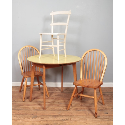 482 - A light oak drop-leaf table with Formica top, together with a pair of 'Goldenpine' chairs and one ot... 