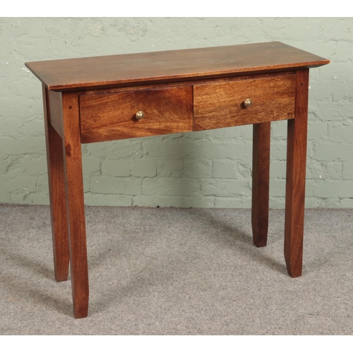 530 - A mahogany two drawer console table featuring tapered supports. Approx. dimensions 94cm x 37.5cm x 8... 