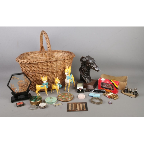 101 - A wicker basket containing an assortment of collectables, to include bronzed greyhound face on bust,... 