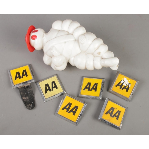 106 - A Michelin man car mascot along with six AA badges.