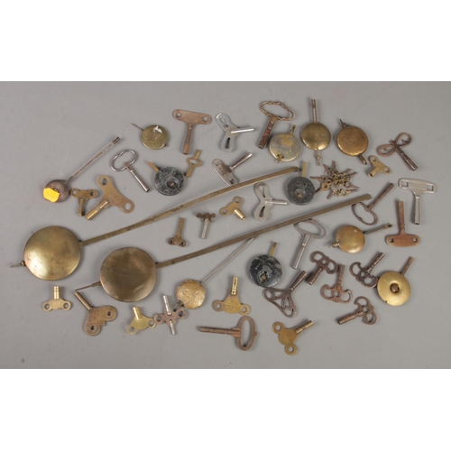 117 - A collection of clock keys, pocket watch keys and pendulums.