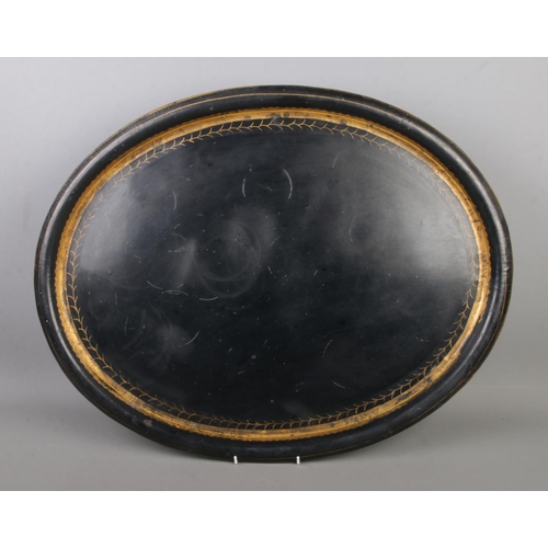 165 - A large tole ware tray featuring gilt decorated border.