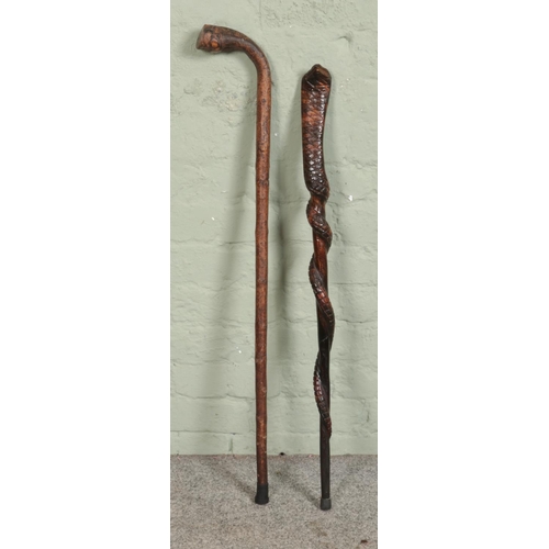 166 - Two hardwood walking sticks, including one carved example formed as a cobra twisted around a cane.