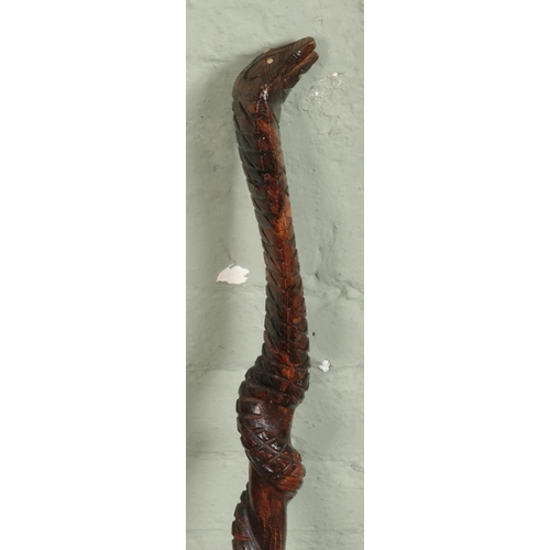 166 - Two hardwood walking sticks, including one carved example formed as a cobra twisted around a cane.