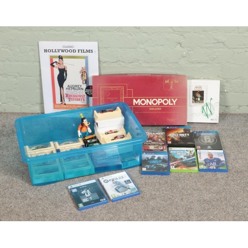 224 - A box of assorted collectables, to include Lledo die cast cars,, Monopoly deluxe and assorted consol... 