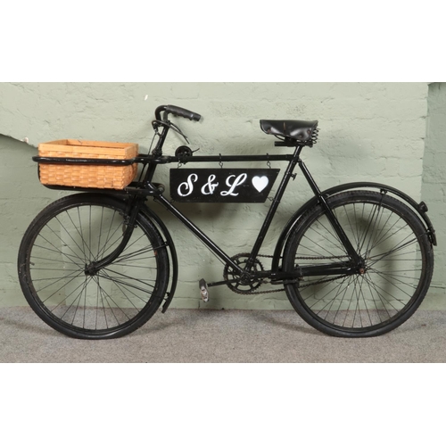 270 - A black painted Butchers 'Tradesman' bike, with wraparound metal fame to the front housing a wicker ... 