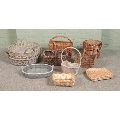 274 - A large collection of wicker baskets and trays, to include small log basket, flower/potato and twin ... 