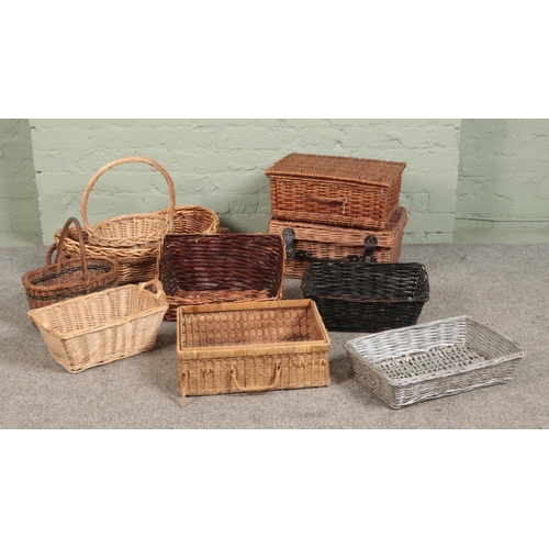 278 - A quantity of wicker basket, to include two hamper baskets, shallow trays and hooped examples.