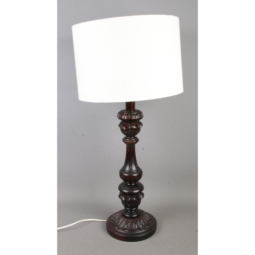 318 - A decorative carved table lamp with cream fabric shade.