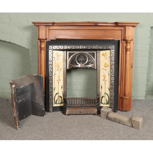 350 - An art nouveau style cast iron tiled fireplace along with modern hardwood mantle.