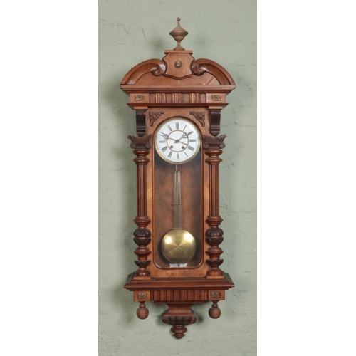 355 - A walnut Vienna style wall clock, with Roman Numeral dial and carved detailing. Chiming on a coiled ... 