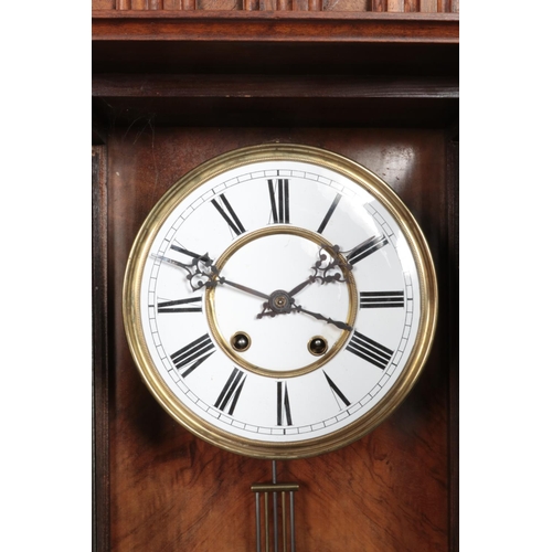 355 - A walnut Vienna style wall clock, with Roman Numeral dial and carved detailing. Chiming on a coiled ... 