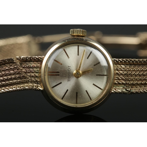 409 - A ladies 9ct Gold Tissot manual wind wristwatch. With silvered dial and baton markers. Stamped to th... 