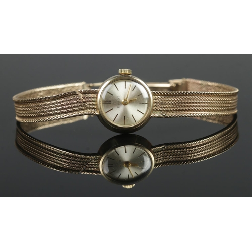 409 - A ladies 9ct Gold Tissot manual wind wristwatch. With silvered dial and baton markers. Stamped to th... 