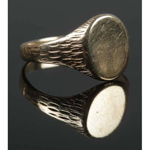 411 - A large 9ct Gold signet ring, with bark detailing to the shoulders. Size V. Total weight: 4.8g.