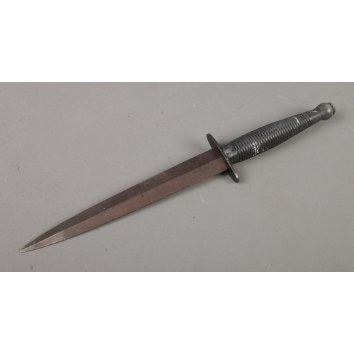 457 - A Fairbairn Sykes pattern commando knife, in sheath. Blade length: 17.6cm. CANNOT POST OVERSEAS.