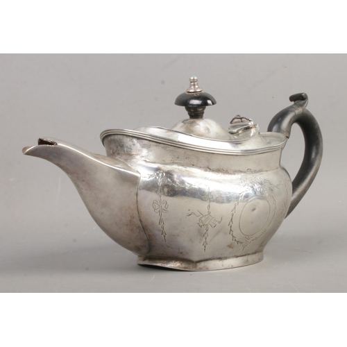 459 - An Edwardian silver teapot of squat form, featuring ebonised handle, swag and bow engraving and blan... 