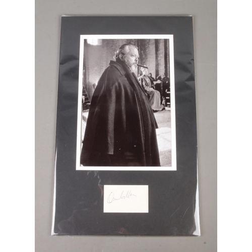 473 - An Orson Welles (1915-1985) autograph mounted alongside monochrome film still.