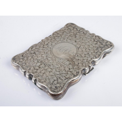 476 - An early Twentieth Century silver hinged card case, heavily engraved with leaf detailing and central... 