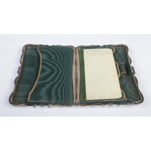 476 - An early Twentieth Century silver hinged card case, heavily engraved with leaf detailing and central... 