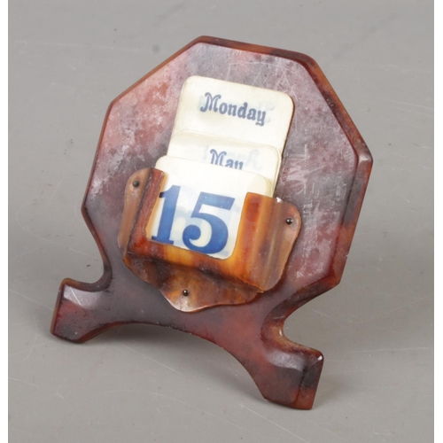 496 - A faux tortoise shell desk calendar.