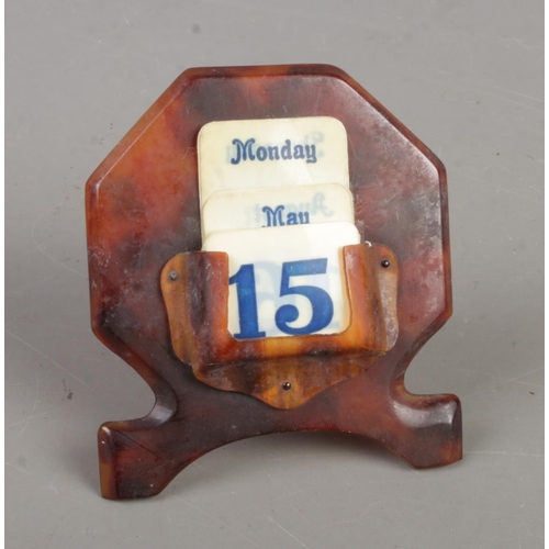 496 - A faux tortoise shell desk calendar.