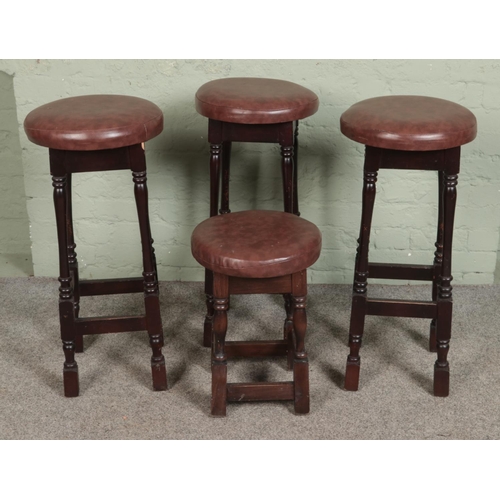 520 - Four modern bar stools, topped with leatherette seat. Three taller and one small example.