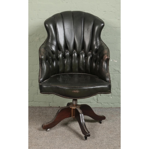 525 - A late 20th century green leather button back swivel desk chair on a swivel base and castors.