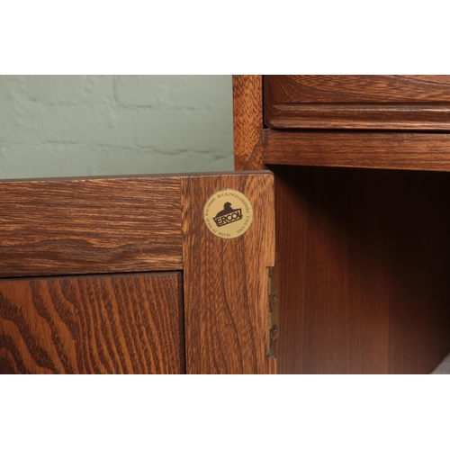 547 - An Ercol elm Canterbury dresser base having a combination of four drawers and three cupboard doors 
... 