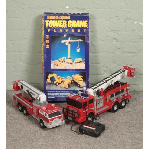 181 - A Lucky Plastic remote control tower crane playset with two remote control fire trucks one by Scient... 