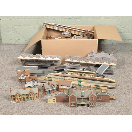 254 - Two boxes of railway diorama accessories including a large quantity of buildings with large platform... 