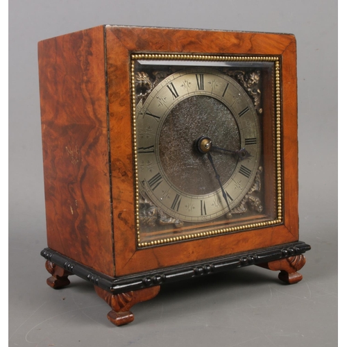 460 - A burr walnut mantel clock of square form with engraved dial with roman numeral markers behind a bev... 