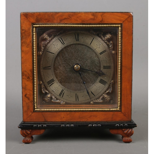 460 - A burr walnut mantel clock of square form with engraved dial with roman numeral markers behind a bev... 