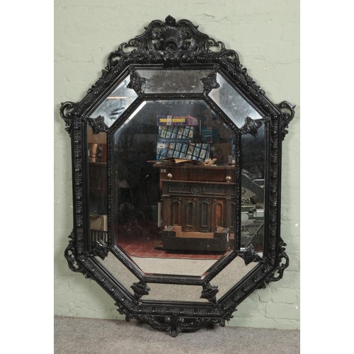 388 - A large octagonal cushion frame mirror surmounted with scrolling acanthus design.

Hx157cm
Wx114cm